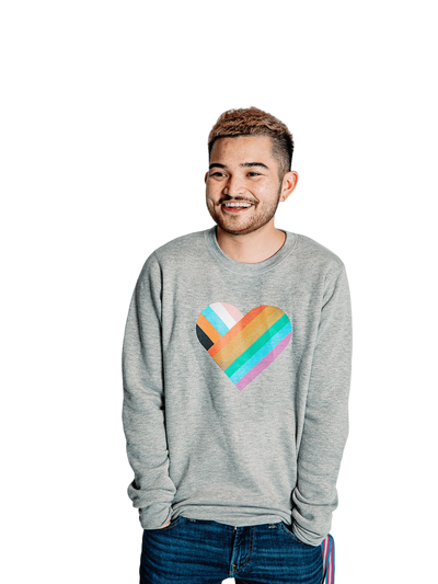 Individual wearing a Pride sweater, radiating pride with a vibrant rainbow heart on their chest.