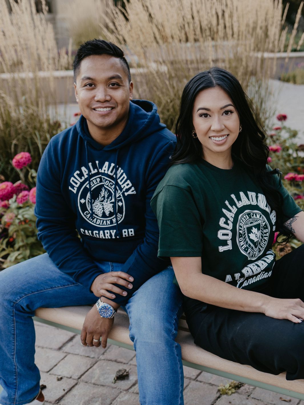 Two individuals wearing their Varsity garments, one is wearing the Navy Varsity Hoodie, and the other the forest green varsity t-shirt. These garments pair perfectly with jeans.