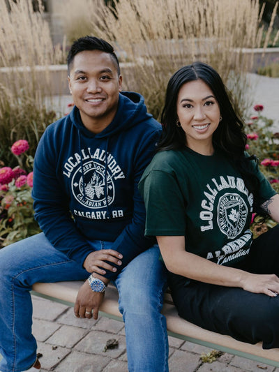 one individual sporting their Local Laundry Variety hoodie in navy with a white graphic, and the other individual wearing their forest green variety t-shirt 