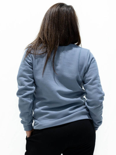 Individual wearing powder blue sweater that is sustainably made in Canada