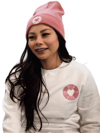 Individual wearing a made in Canada sweater that features the Ryder's foundation heart on the left chest. The individual is wearing a matching made in Canada Ryder's foundation hat in faded rose.