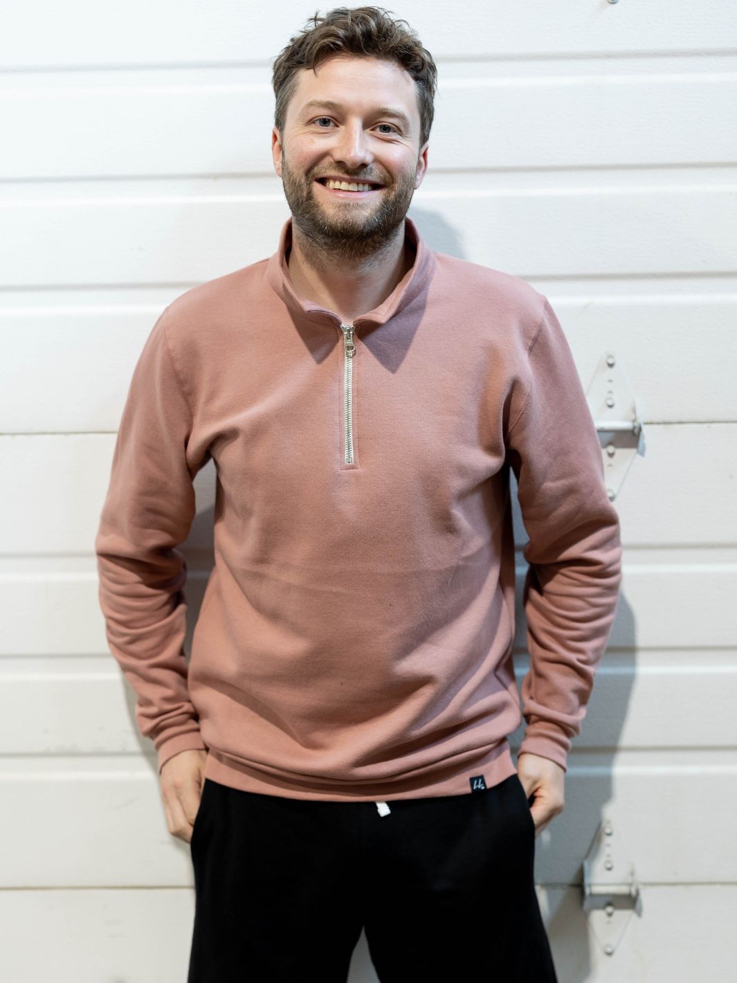 Happy individual wearing a made in Canada Local Laundry 3/4 zip pullover sweater in dusty rose. The individual has paired this item with a pair of Local Laundry Sweat shorts in black.