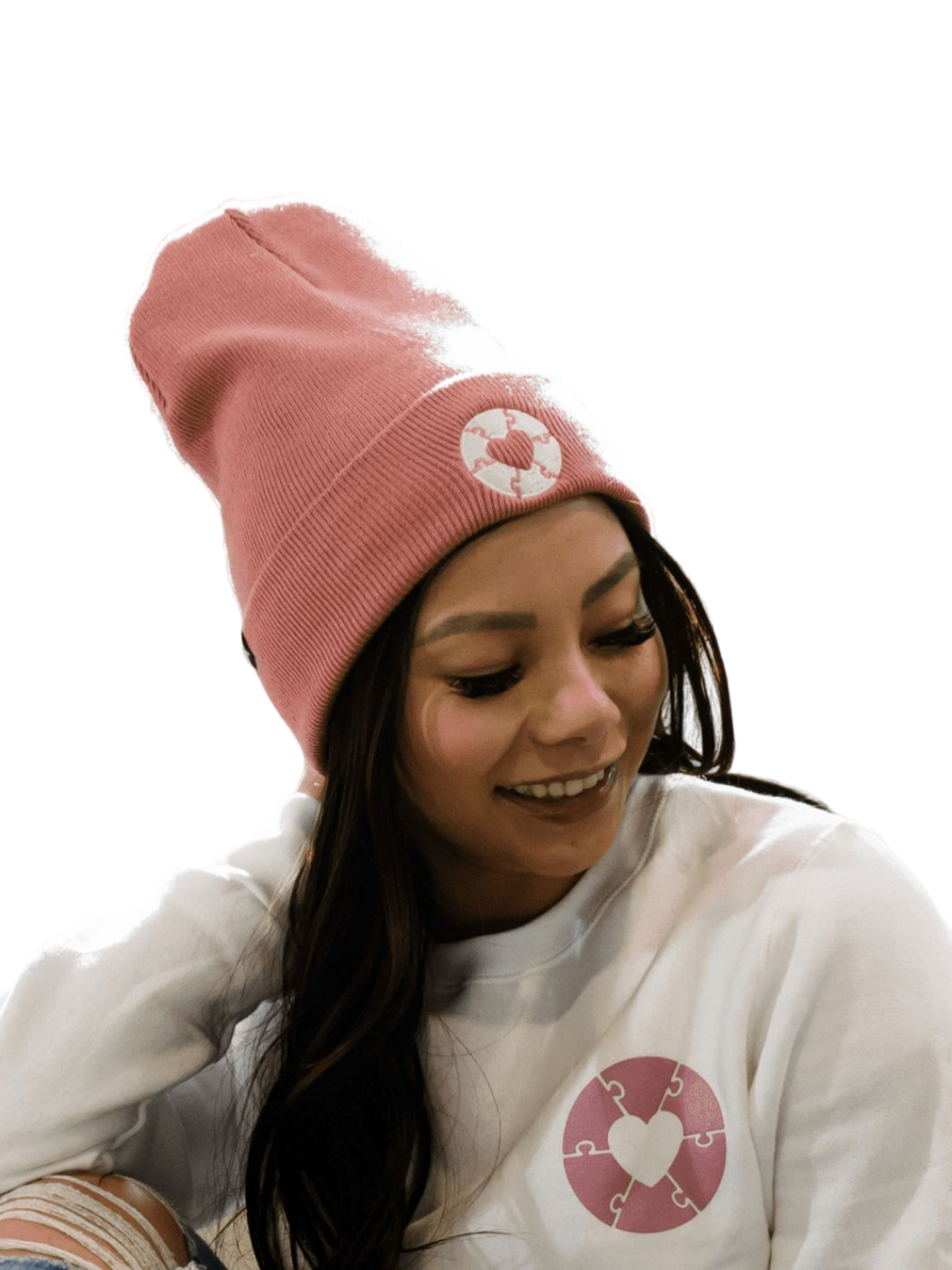 Individual wearing faded rose coloured hat that features a white heart sewn patch. This hat is a collaboration piece between Local Laundry and the Ryder's Foundation to support those diagnosed with autism. These toques are sustainably sourced and manufactured in Canada.