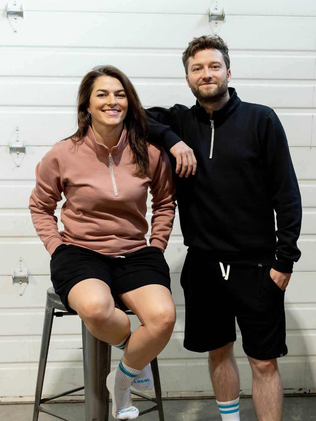 Two individual's showcasing the Local Laundry Greenview 3/4 zip in both black and dusty rose. This garment is made in Canada, and is constructed of a premium blend of 50% cotton and 50% polyester.