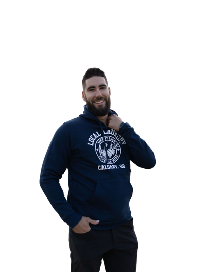 individual wearing the Local Laundry Varsity hoodie in navy blue with a white graphic on the front torso. This hoodie is sustainably made in Canada from a premium blend of 50% cotton, and 50% polyester