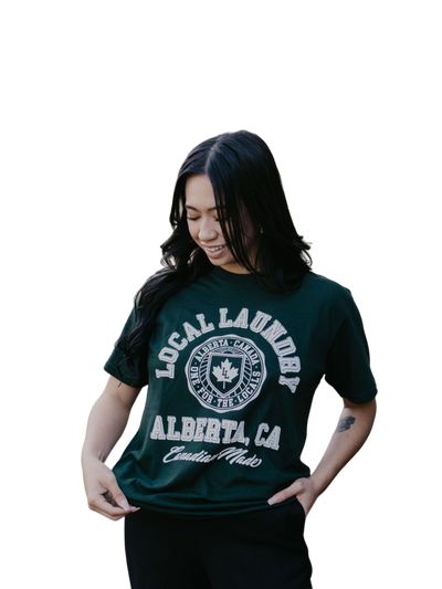 Individual sporting the Local Laundry Forest Green Varsity t-shirt, featuring a contrasting white graphics exclusive to Local Laundry. Canadian made fashion that is sustainable and ethical.