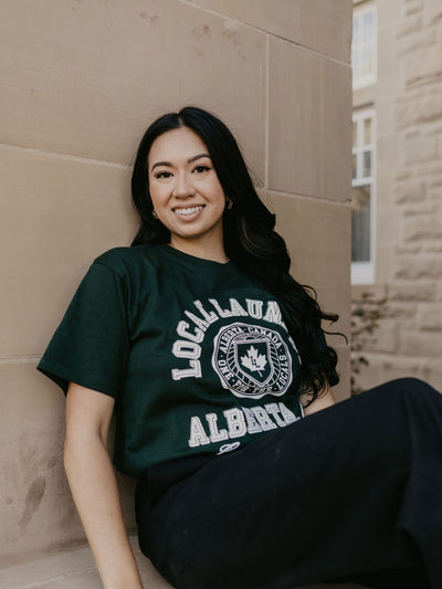 Individual wearing the Varsity t-shirt in forest green featuring an exclusive Local Laundry graphic. Made in Canada. Sustainable, local fashion.