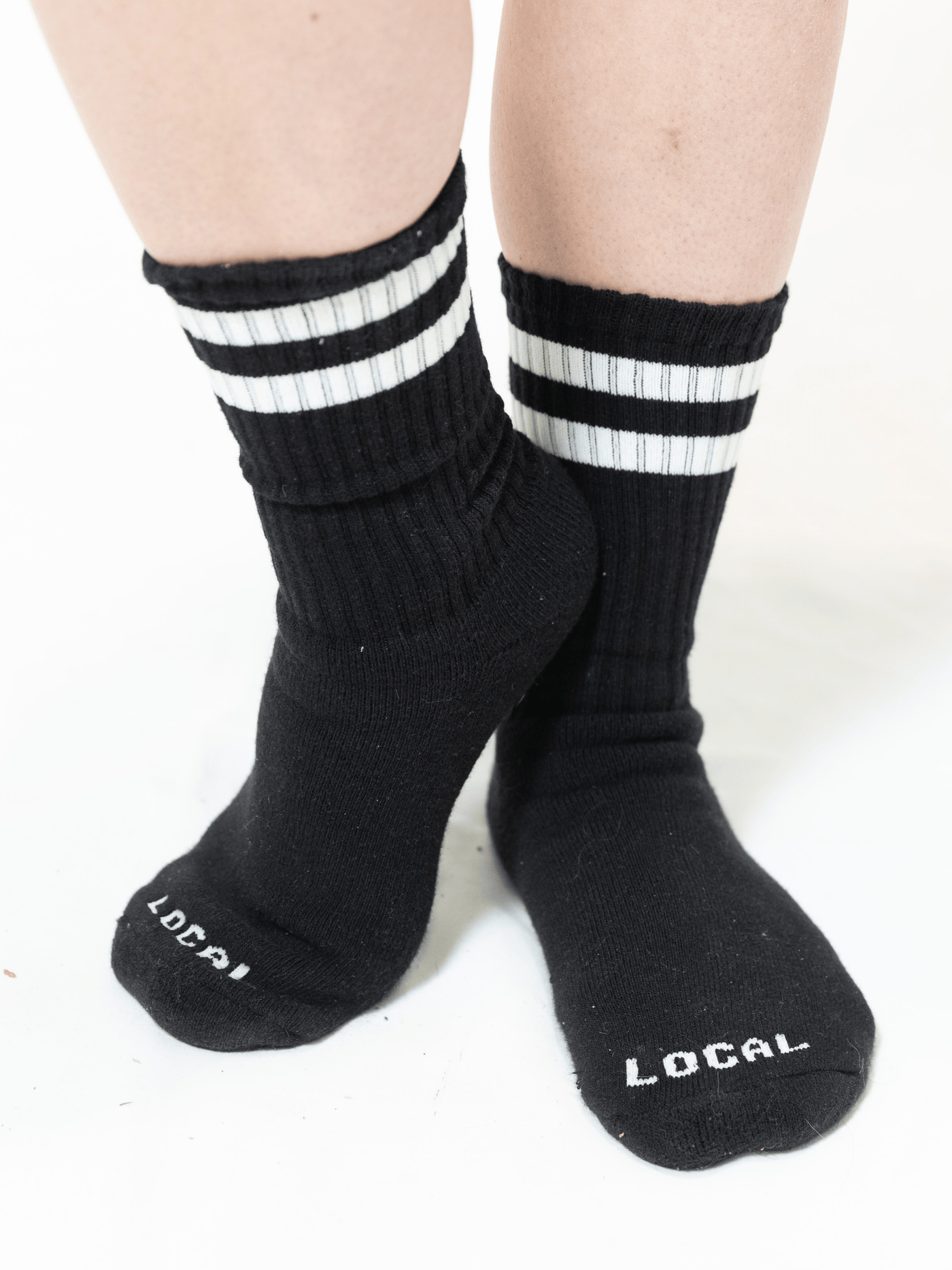 Local Laundry Giving Sock in Black with White contrast stripes. Every purchase of these socks goes towards giving socks to those in need 