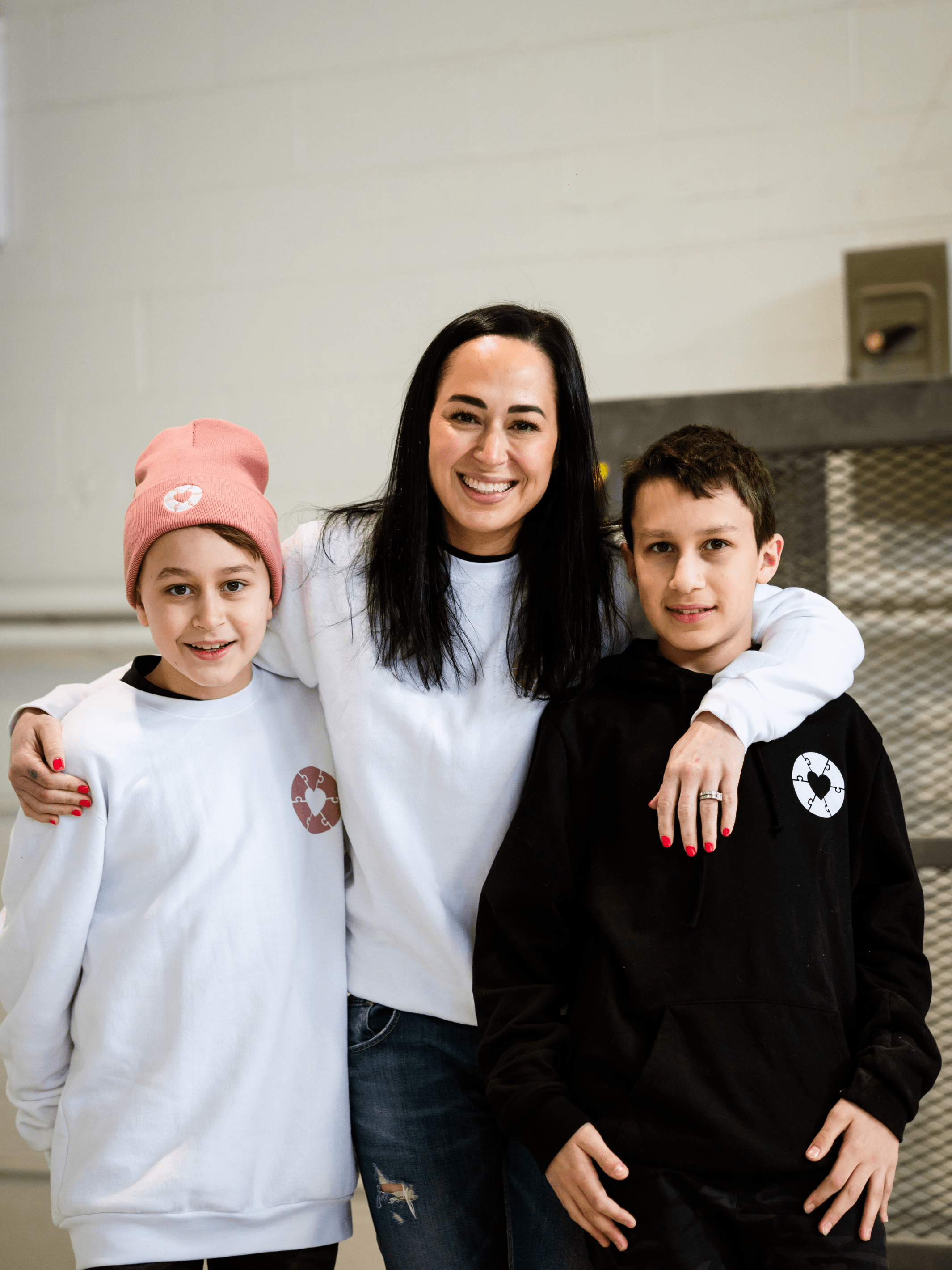 Three individuals sporting made in Canada sweaters that feature a white heart graphic representing the Ryder's Foundation. Made in Canada - Local Laundry