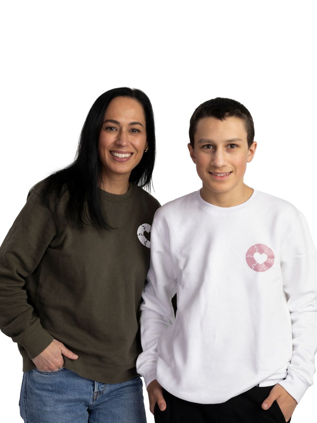 Two individuals wearing made in Canada sweaters that feature heart graphics on the left chest. These sweaters are done in collaboration between Local Laundry and the Ryder's Foundation to support those with autism. These sweaters are sustainably manufactured and sourced. All of the proceeds from these sweaters is donated to charities for autism.