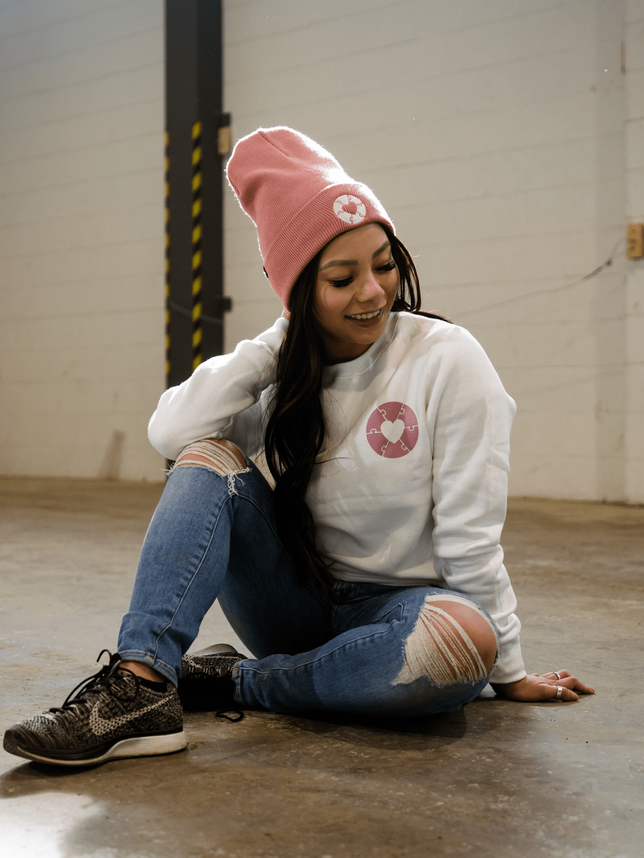 Individual wearing made in Canada sweater that features the Ryder's foundation logo on the left chest in faded rose color.
