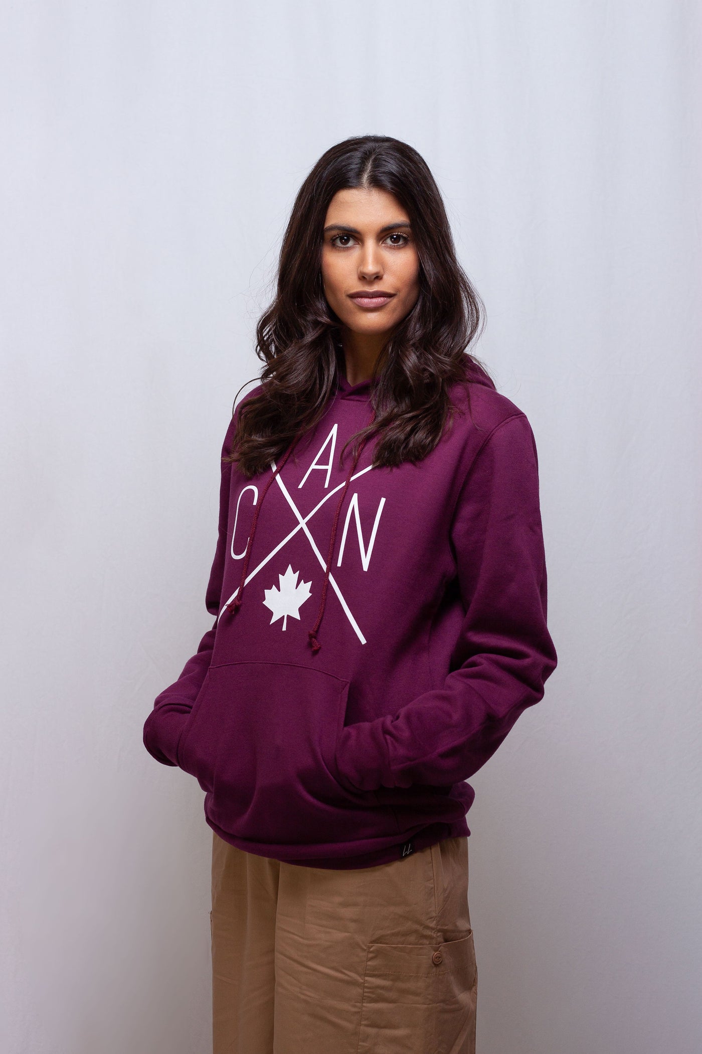 Individual wearing maroon Canadian made Hoodie featuring a Local Laundry trademarked CAN Maple Leaf Design. Wearing this hoodie supports local communities and economies.