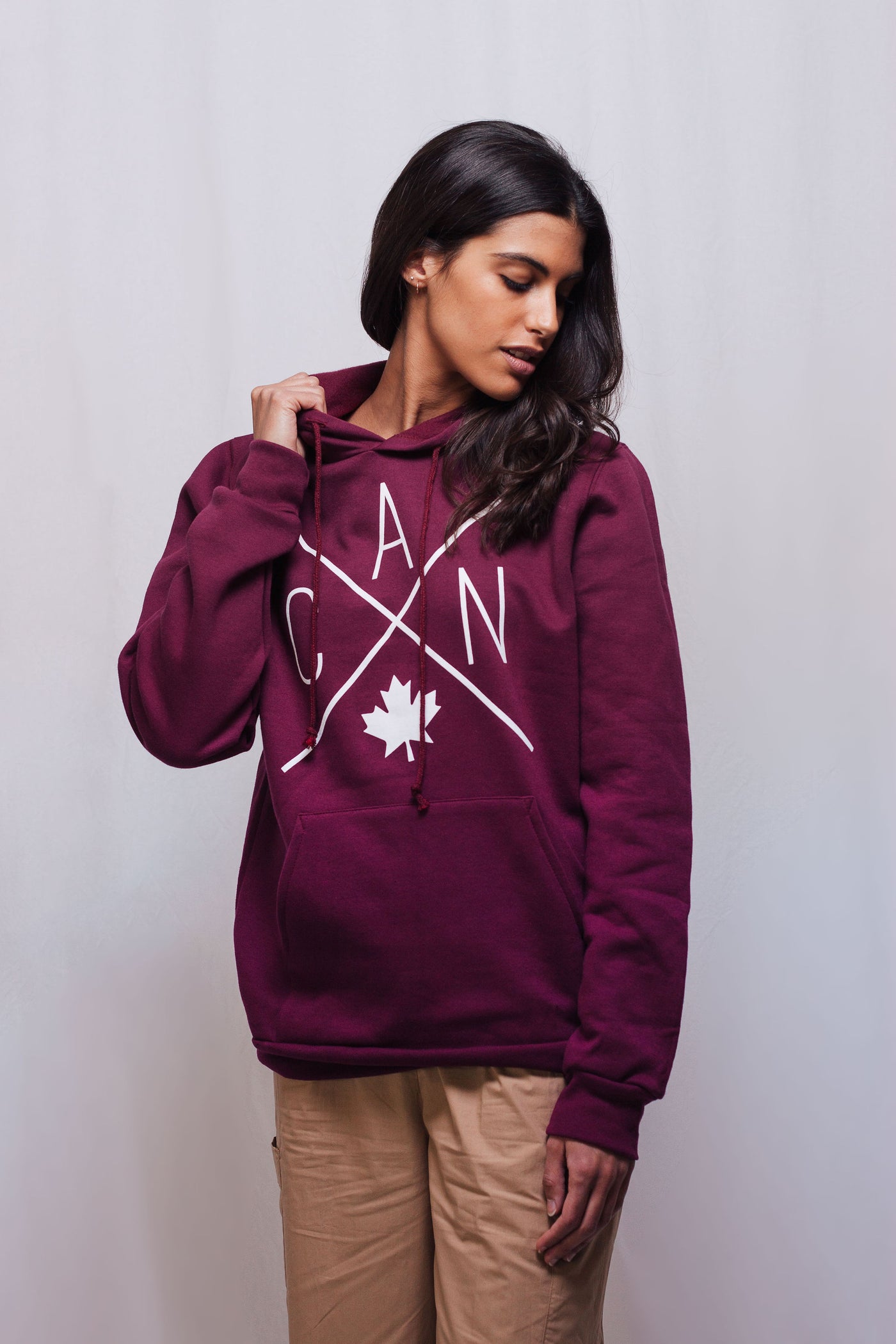 Individual sporting Canadian made hoodie featuring a Local Laundry trademarked CAN Maple Leaf design in limited maroon colour. 