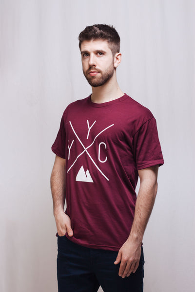 Individual showcasing the YYC T-shirt by Local Laundry in maroon colour. This t-shirt is proudly made in Canada.